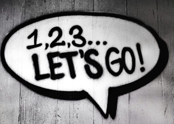 Black and white street art featuring a bold motivational message in a speech bubble.